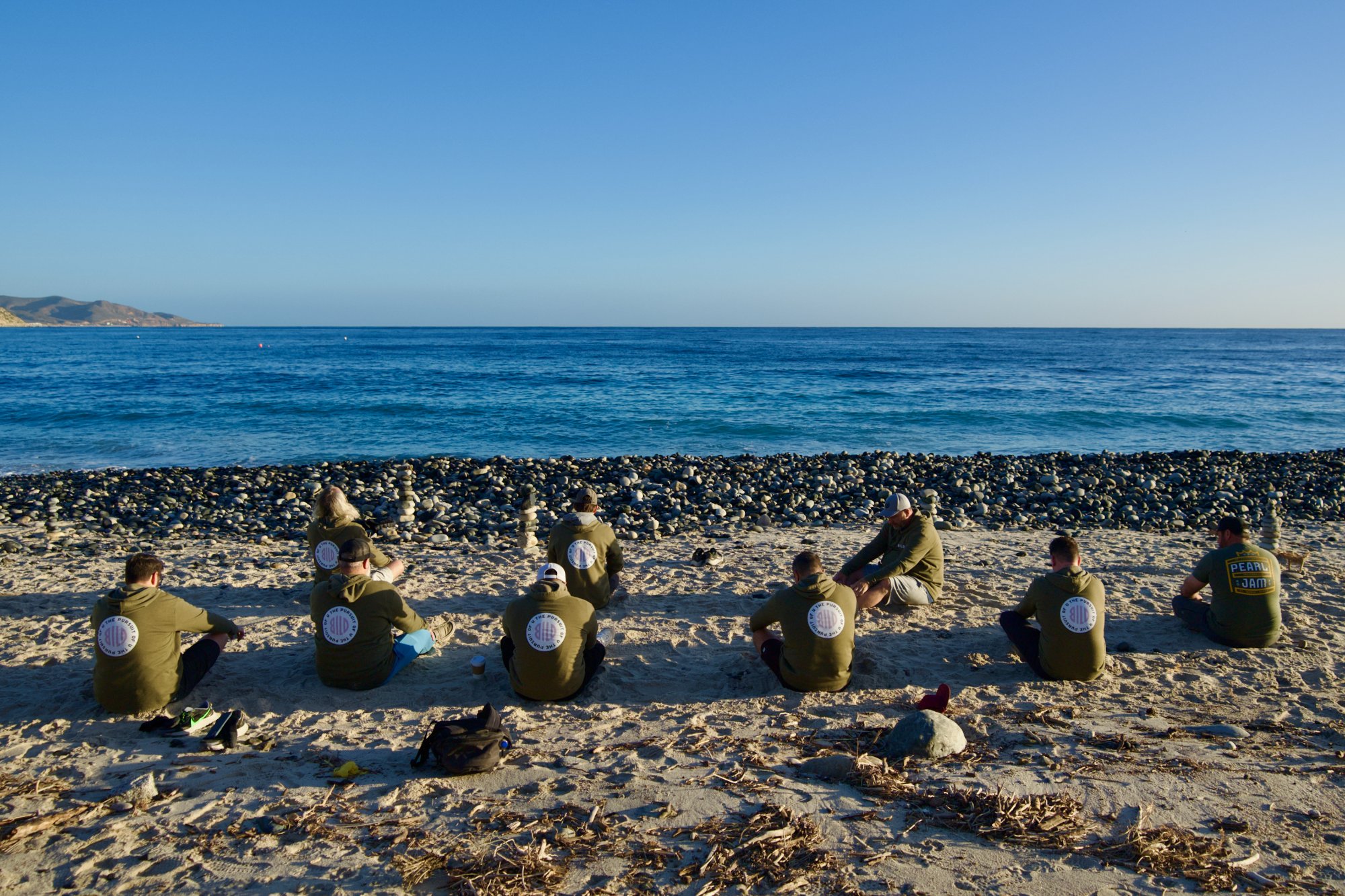 Men sitting facing the sea