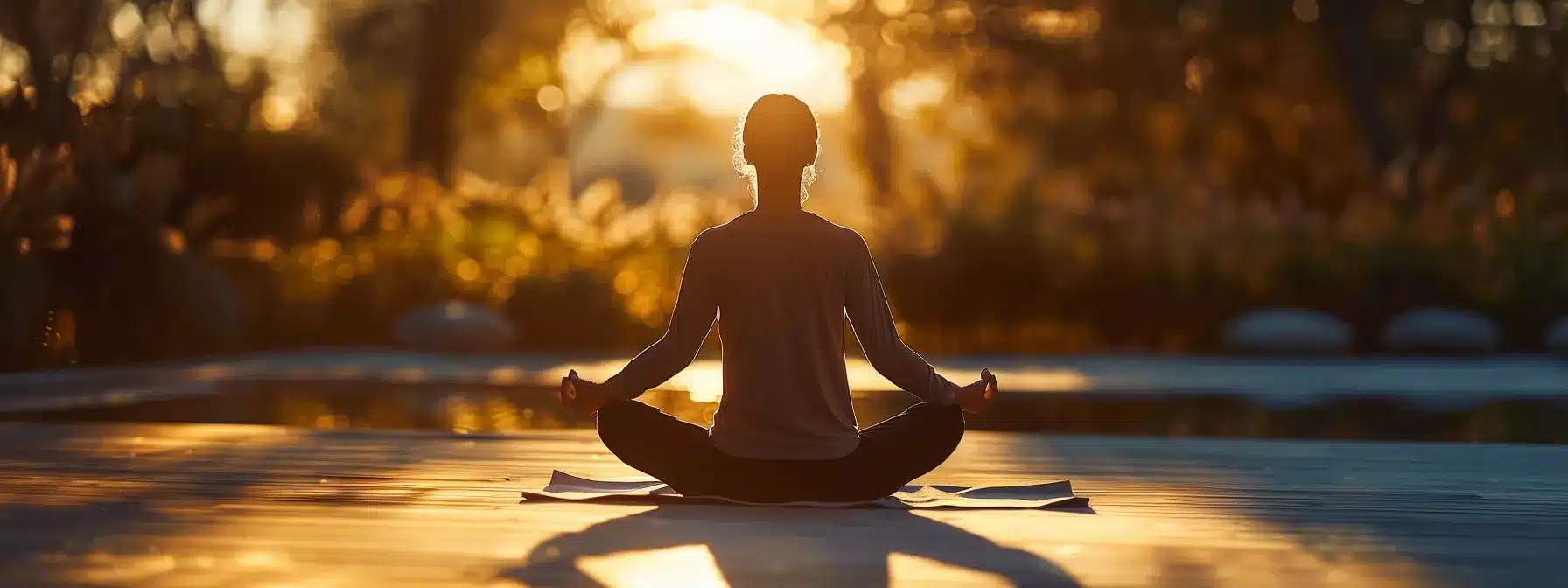 a person meditating in a tranquil outdoor setting, fully present in the moment.